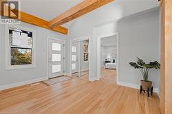 Foyer with beamed ceiling and light wood-type flooring -