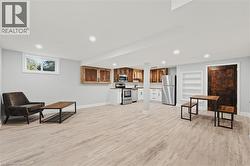 Living area with light wood finished floors and recessed lighting -