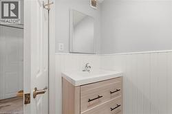 Bathroom featuring vanity, wainscoting, and wood finished floors -