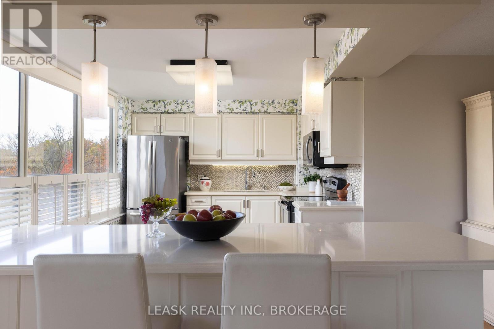 Sun-lit kitchen w/breakfast bar & treelined views. - 303 - 3 Towering Heights Boulevard, St. Catharines (Glendale/Glenridge), ON - Indoor Photo Showing Kitchen With Upgraded Kitchen
