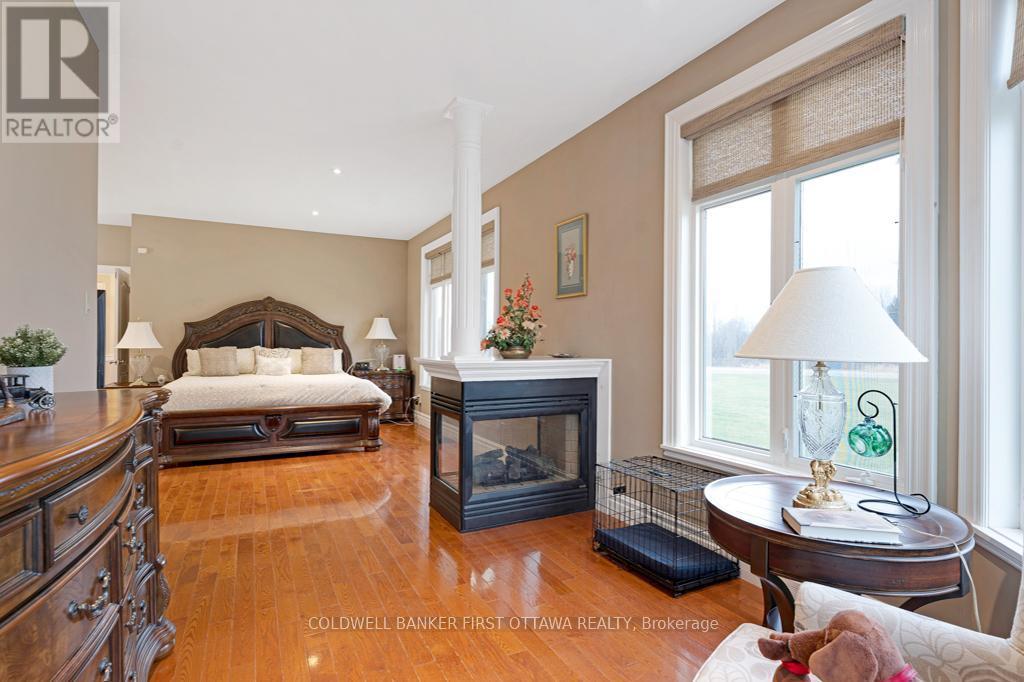 Primary suite oasis has three-sided fireplace - 556 West Point Drive, Drummond/North Elmsley, ON - Indoor With Fireplace