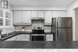 Sleek SS appliances & modern tile backsplash -