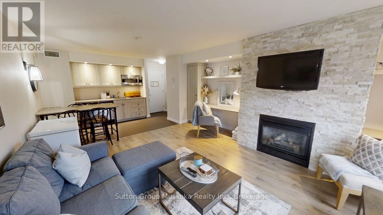 52-308 - 1235 Deerhurst Drive, Huntsville (Chaffey), ON - Indoor Photo Showing Living Room With Fireplace