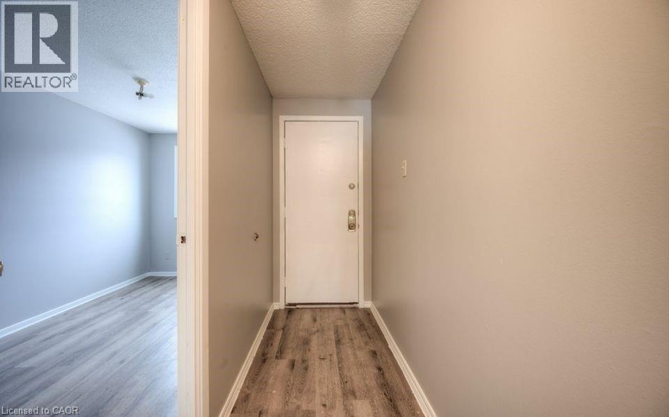 Corridor featuring light wood-style floors and a textured ceiling - 1200 Courtland Avenue E Unit# 25, Kitchener, ON - Indoor Photo Showing Other Room