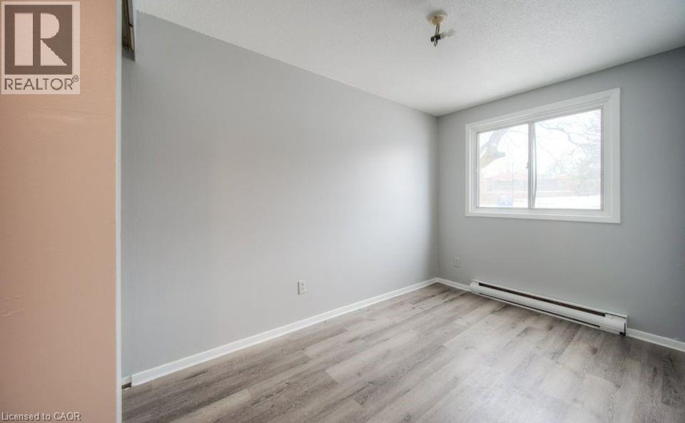 Spare room with a baseboard heating unit and light wood-type flooring - 1200 Courtland Avenue E Unit# 25, Kitchener, ON - Indoor Photo Showing Other Room