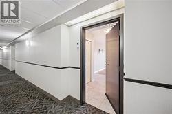 Hallway with a paneled ceiling and tile patterned floors -
