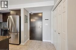 Kitchen featuring appliances with stainless steel finishes, dark brown cabinetry, decorative backsplash, modern cabinets, and light tile patterned flooring -