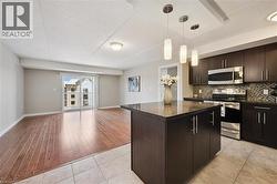 Kitchen featuring stainless steel appliances, open floor plan, backsplash, a kitchen island, and a textured ceiling -