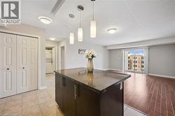 Kitchen featuring a textured ceiling, a center island, decorative light fixtures, open floor plan, and light tile patterned flooring -