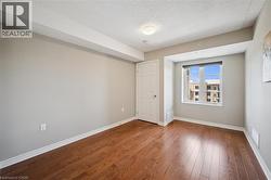Unfurnished bedroom with a textured ceiling and wood finished floors -