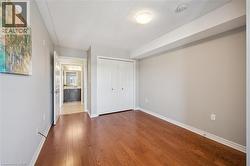 Unfurnished bedroom with a textured ceiling, dark wood-style floors, and a closet -