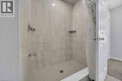 Bathroom featuring a tile shower and tile patterned floors -
