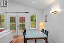 Dining area with french doors, wood finished floors, vaulted ceiling, and recessed lighting -