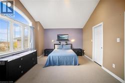 Bedroom with light colored carpet and vaulted ceiling -