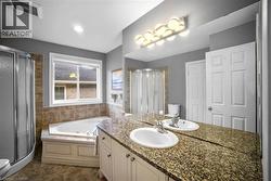 Full bath featuring vanity, a shower stall, and a tub with jets -