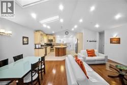 Living area with vaulted ceiling and light wood-type flooring -
