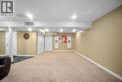 Finished below grade area with carpet flooring and recessed lighting -
