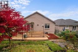 Rear view of house featuring a deck and brick siding -