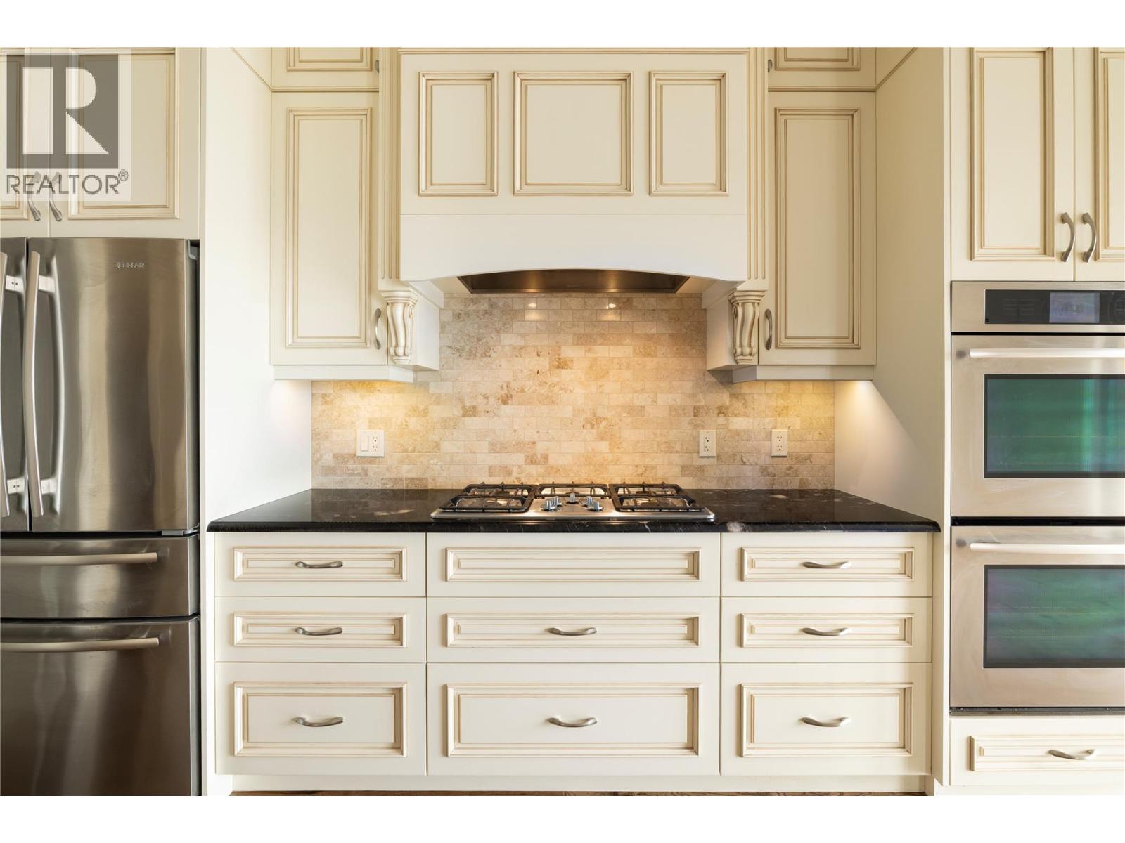 Chef's Inspired Kitchen Featuring JennAir Appliances Including 5 Burner Gas Range, Double Ovens, and Fridge/Freezer - 108 Vineyard Way, Vernon, BC - Indoor Photo Showing Kitchen With Upgraded Kitchen