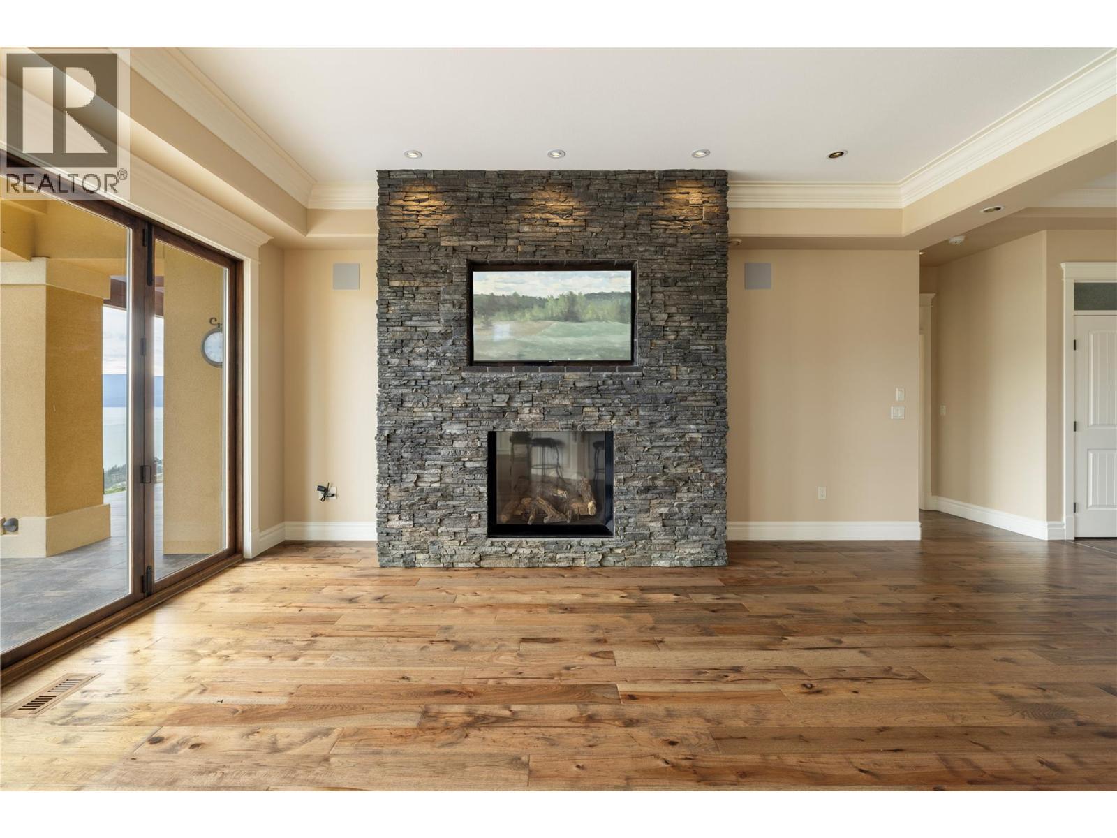 Floor-to-ceiling Stone Finished Fireplace with T.V. Inlay - 108 Vineyard Way, Vernon, BC - Indoor With Fireplace