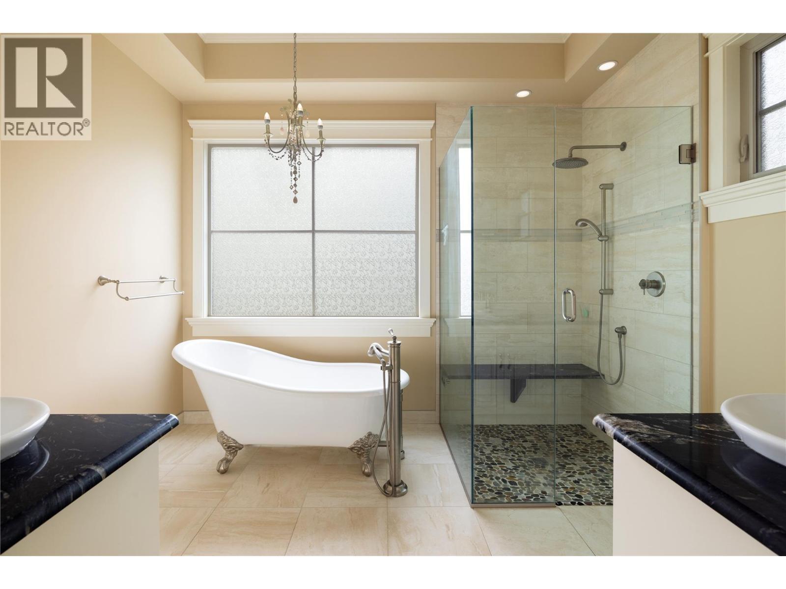 Spa-Inspired Primary Ensuite Featuring Clawfoot Tub, Tile Shower with Dual Shower Heads, and Dual Sinks with Under Cabinet Lighting - 108 Vineyard Way, Vernon, BC - Indoor Photo Showing Bathroom