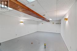 Below grade area featuring a drop ceiling and baseboards -