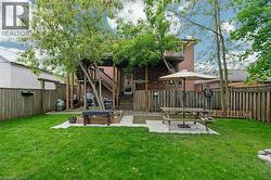 Rear view of house featuring a patio, brick siding, and stairs -