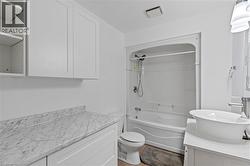Bathroom featuring vanity, shower / bath combination, and toilet -