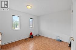 Spare room featuring wood finished floors and baseboards -