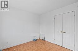 Unfurnished bedroom with light wood finished floors and baseboards -
