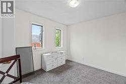 Carpeted bedroom with a textured ceiling and baseboards -