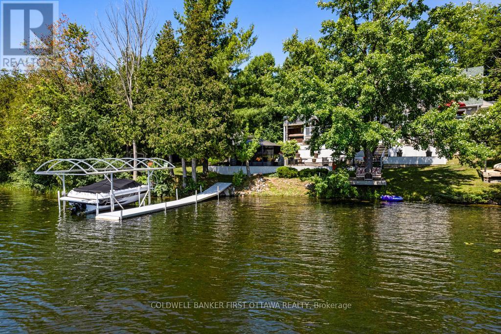 Dock with boat lift - 320 Pike Lake Route 12 Road, Tay Valley, ON - Outdoor With Body Of Water