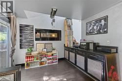 Rec room featuring dark wood-style flooring and a textured wall -