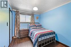 Bedroom featuring dark wood-type flooring and a textured ceiling -