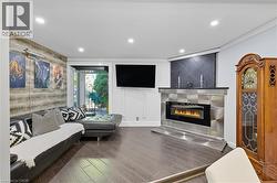 Living area featuring a glass covered fireplace, wood finished floors, recessed lighting, and a textured ceiling -