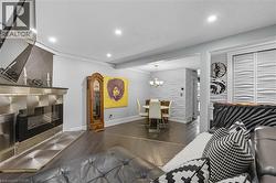 Living area with dark wood-type flooring, recessed lighting, a chandelier, and beamed ceiling -