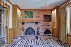 Wall-to-wall brick fireplace; B/I bookcases. -