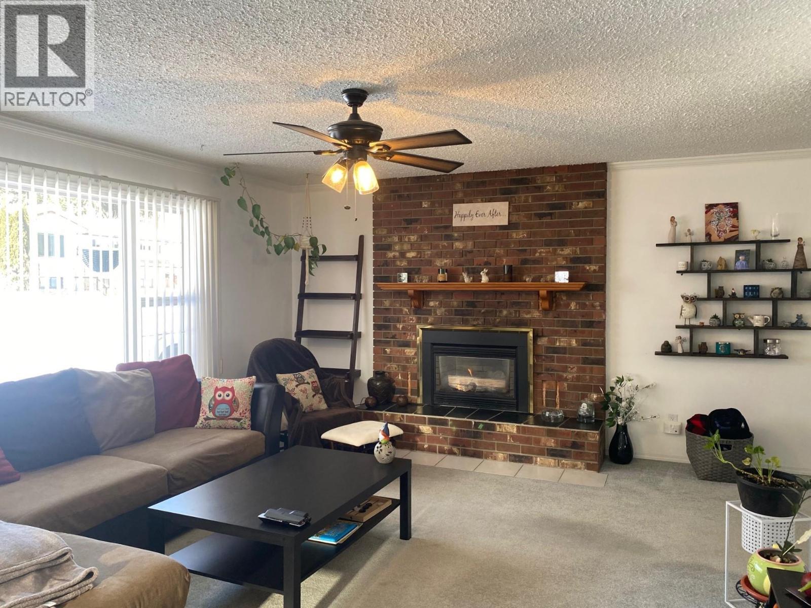 Bright and spacious living room - 1768 First Street, Fruitvale, BC - Indoor Photo Showing Living Room With Fireplace