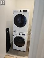 Laundry room featuring stacked washer and clothes dryer, baseboards, and laundry area -