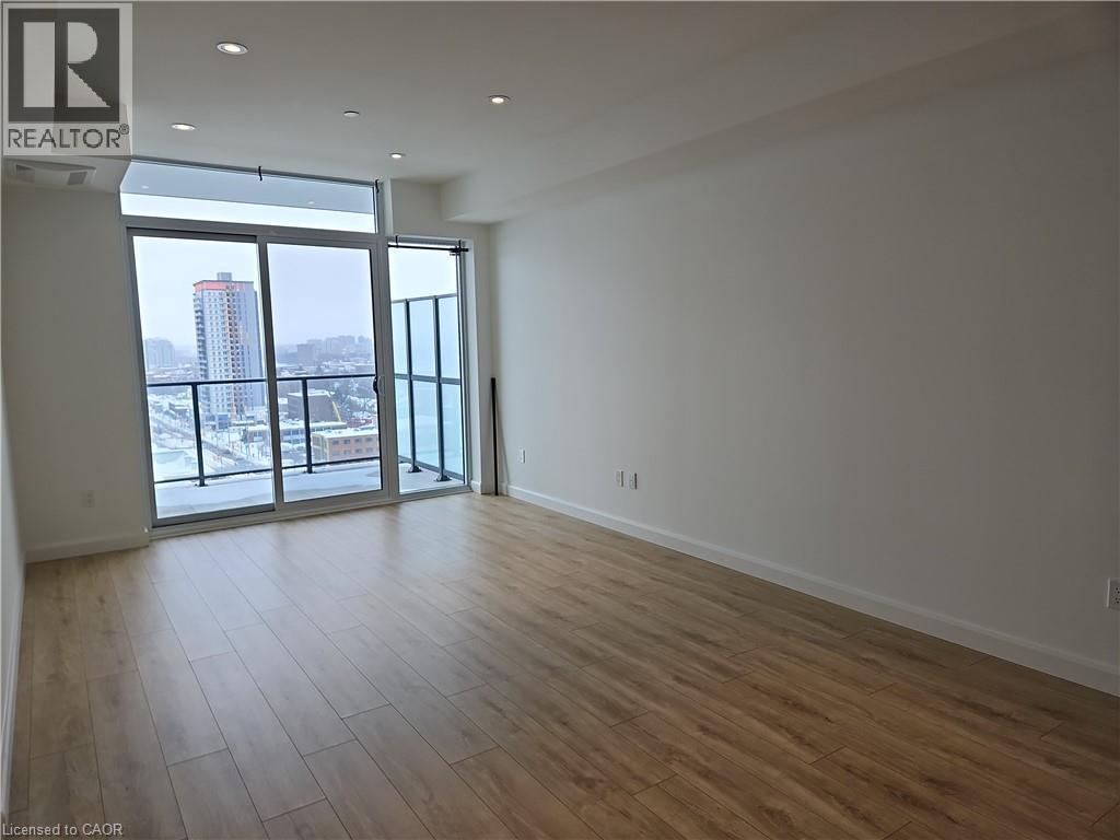 Unfurnished room with a view of city, floor to ceiling windows, recessed lighting, wood finished floors, and baseboards - 741 King Street W Unit# 1207, Kitchener, ON - Indoor Photo Showing Other Room