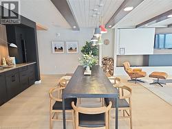 Dining space featuring sink, beam ceiling, wood ceiling, and light hardwood / wood-style flooring -