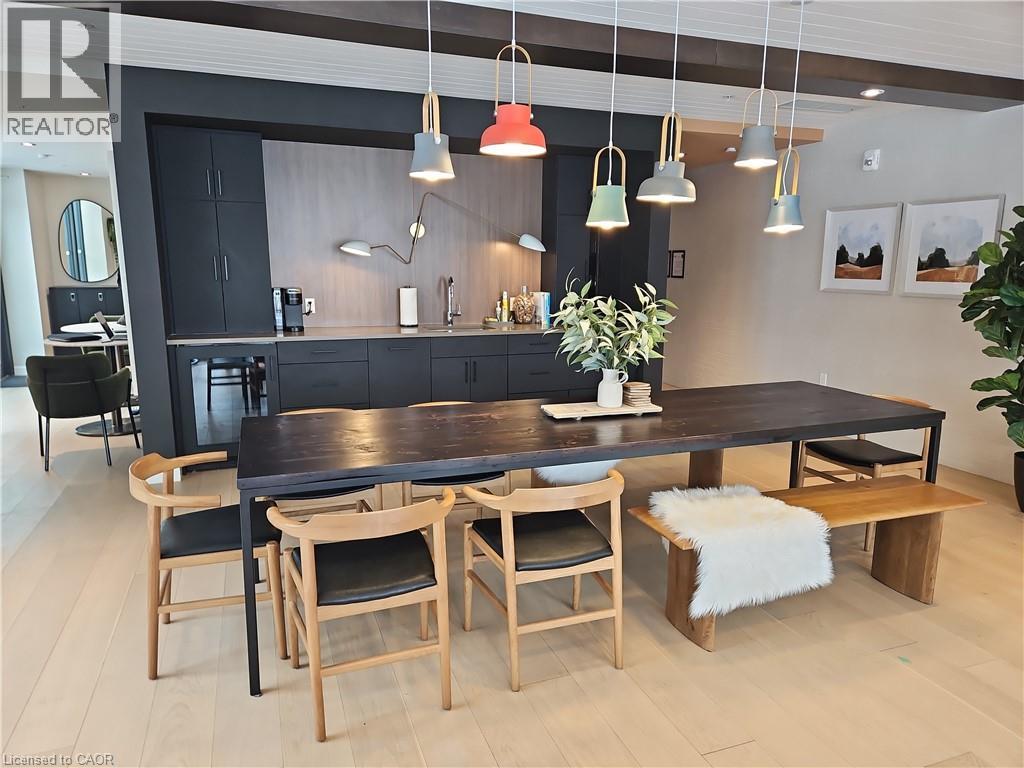 Dining area with beam ceiling and light wood-type flooring - 741 King Street W Unit# 1207, Kitchener, ON - Indoor Photo Showing Dining Room