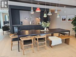 Dining area with beam ceiling and light wood-type flooring -