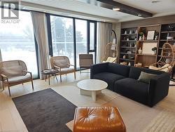 Living area with beam ceiling, light hardwood / wood-style floors, built in shelves, and a wealth of natural light -