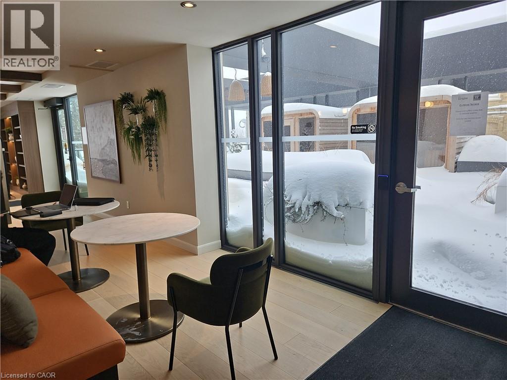 Doorway to outside featuring light hardwood / wood-style flooring and a wall of windows - 741 King Street W Unit# 1207, Kitchener, ON - Indoor Photo Showing Other Room