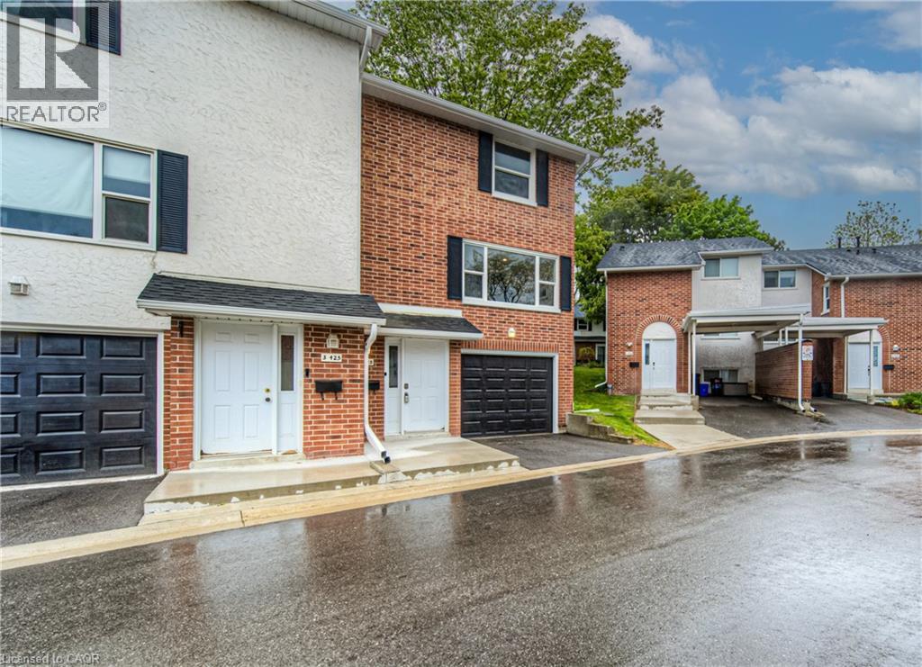 Multi unit property with an attached garage, asphalt driveway, brick siding, and stucco siding - 425 Keats Way Unit# 4, Waterloo, ON - Outdoor With Facade