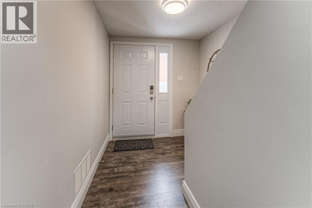 Foyer with a textured ceiling, dark wood-style flooring, and baseboards - 425 Keats Way Unit# 4, Waterloo, ON - Indoor Photo Showing Other Room