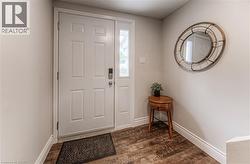 Foyer entrance with dark wood finished floors and baseboards -