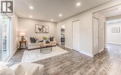 Living room with wood finished floors, recessed lighting, and baseboards -