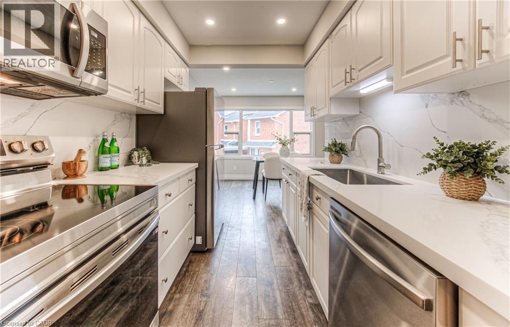 Kitchen featuring stainless steel appliances, a sink, dark wood-style floors, recessed lighting, and white cabinetry - 425 Keats Way Unit# 4, Waterloo, ON - Indoor Photo Showing Kitchen With Upgraded Kitchen